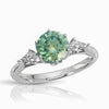 green round moissanite ring with kite cut moissanite side stone