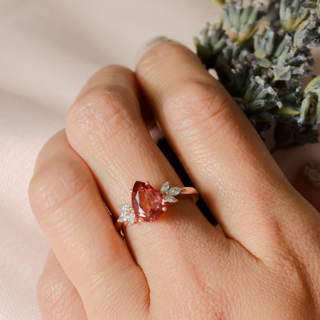 teardrop Padparadscha pink sapphire ring on finger